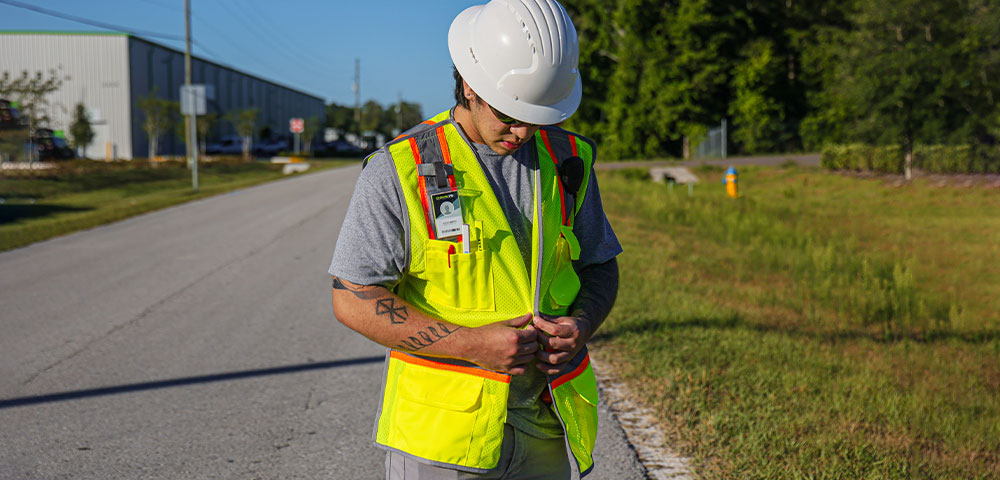 Road worker adjusting DOME75 DV2123BA Safety Veset on side of road