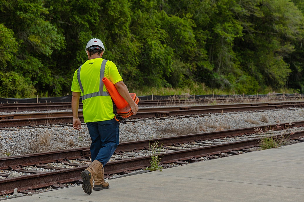man wearing hi-vis shirt carrying cones